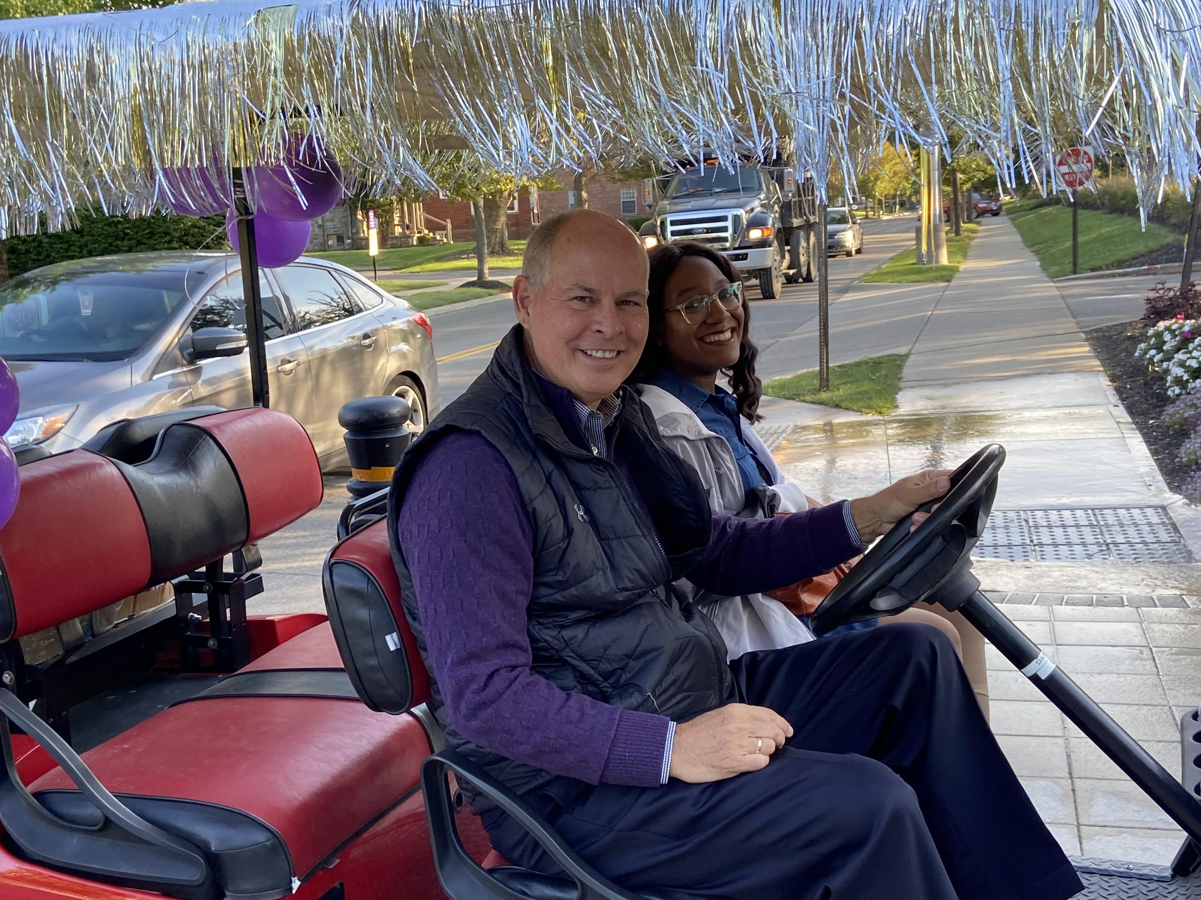 President Kaufman Driving Golf Cart With Bree Chambers